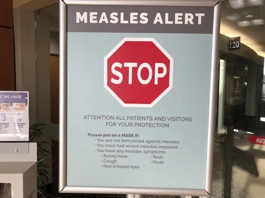 In this 30 January 2019 photo, signs posted at the Vancouver Clinic in Vancouver, Washington, warn patients and visitors of a measles outbreak. Photo: Gillian Flaccus / AP