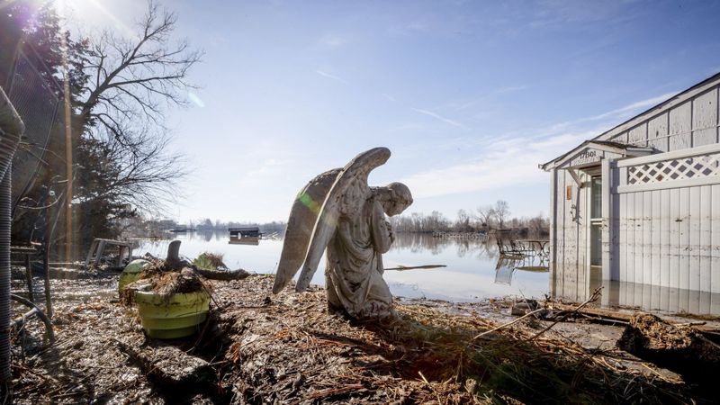 An angel statue in a flooded yard near Hansen Lake in Bellevue, Nebraska, 22 March 2019. Residents were allowed into the area for the first time since floodwaters overtook several homes. Photo: Kent Sievers / Associated Press