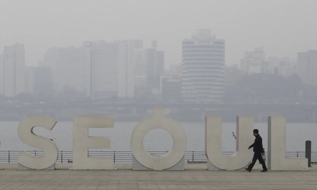 A man wearing a mask to protect from air pollution walks along the Han river at a park in Seoul on 12 March 2019. Photo: Lee Jin-man / AP