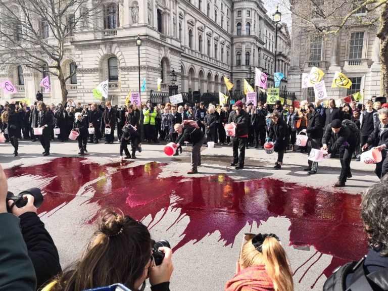 Members of the organisation Extinction Rebellion pour artificial blood during a climate protest outside 10 Downing Street in London, United Kingdom, 9 March 2019. Photo: Holly-Anna Petersen / Christian Climate Action