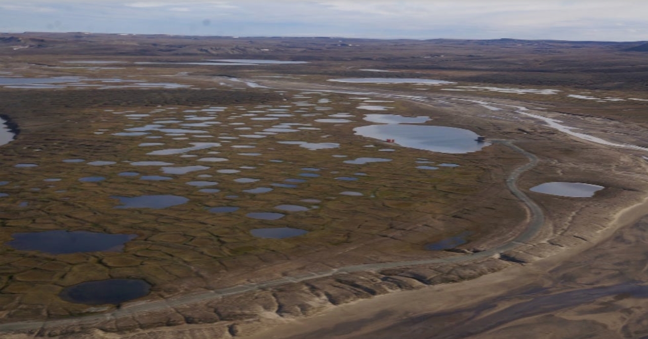 Aerial view of melting permafrost near a research site in Arctic Canada. The unprecedented melt rate creates thermokarst, an irregular landscape dotted by lakes, holes, and mounds. Photo: Louise Farquharson