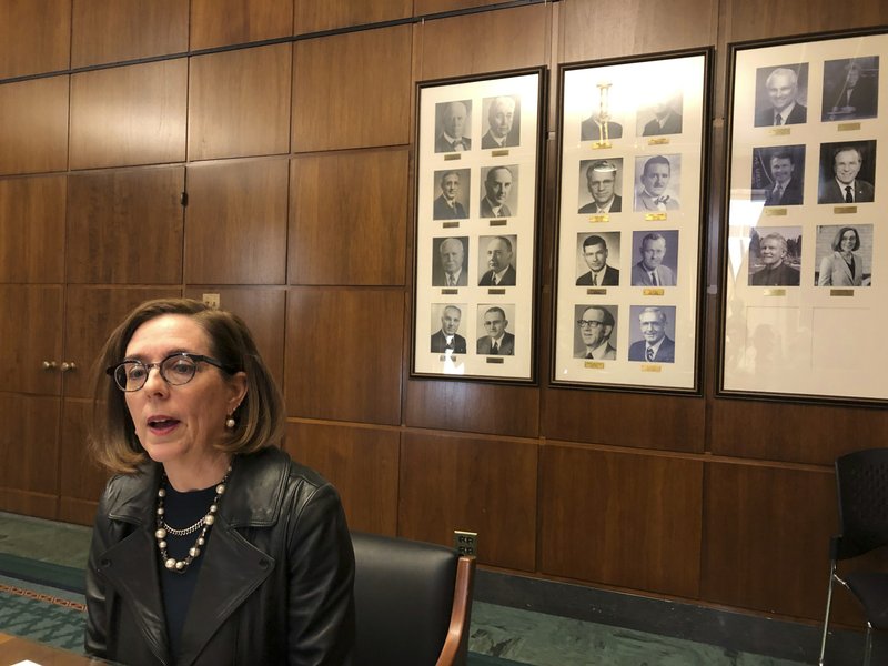 Oregon Governor Kate Brown speaks to reporters in front of pictures of previous state governors in Salem, Oregon, 7 February 2019. Gov. Brown deployed the state police on Thursday, 20 June 2019, to try to round up Republican lawmakers who fled the Capitol in an attempt to block a vote on a landmark climate plan. Minority Republicans want the cap and trade proposal aimed at dramatically lowering the state's greenhouse gas emissions by 2050 to be sent to the voters for approval instead of instituted by lawmakers. Photo: Andrew Selsky / AP Photo