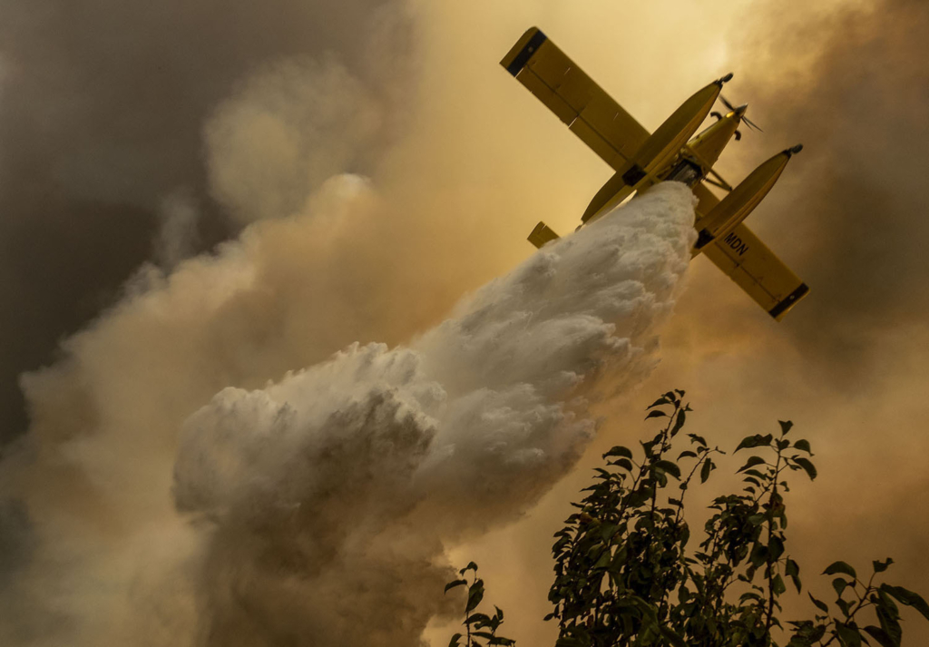 A firefighting airplane operates over a fire in the village of Chaveira, near Macao, in central Portugal, on 22 July 2019. Photo: Sergio Azenha / AP