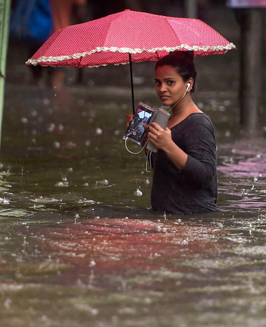 A woman wades through a flooded street during monsoon rain in Mumbai, July 2019. Photo: PTI