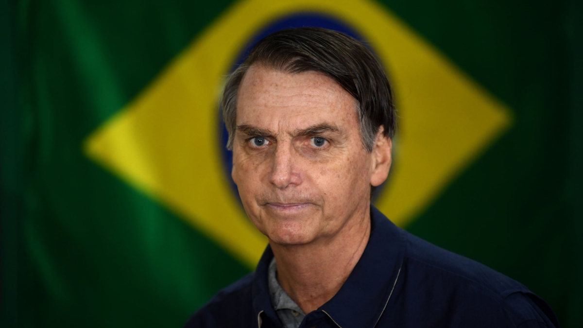 President Jair Bolsonaro is framed by the national flag of Brazil. Recently, his “popularity is falling because people feel baffled by the things he is doing and saying”, according to one conservative columnist. Photo: Mauro Pimentel / AFP / Getty Images
