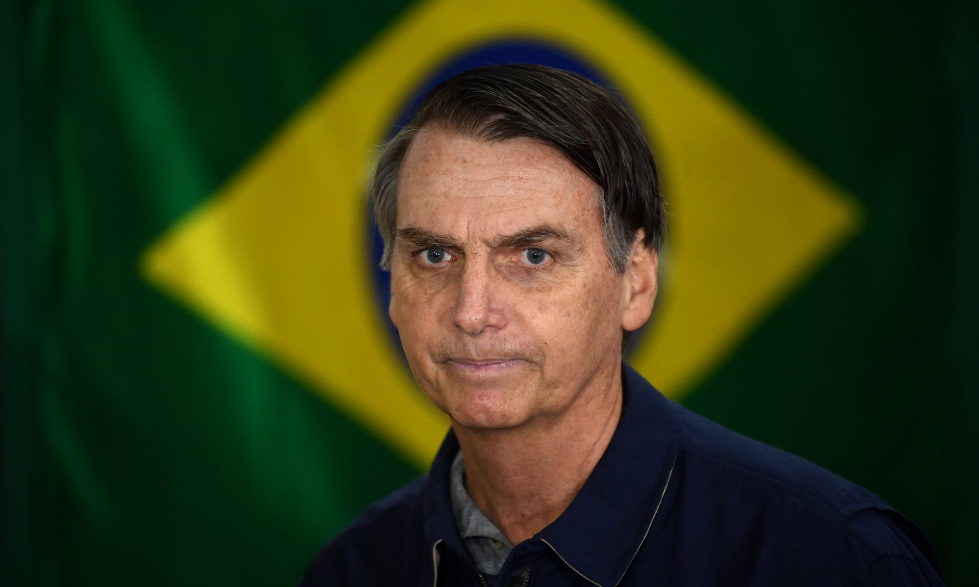 President Jair Bolsonaro is framed by the national flag of Brazil. Recently, his “popularity is falling because people feel baffled by the things he is doing and saying”, according to one conservative columnist. Photo: Mauro Pimentel / AFP / Getty Images
