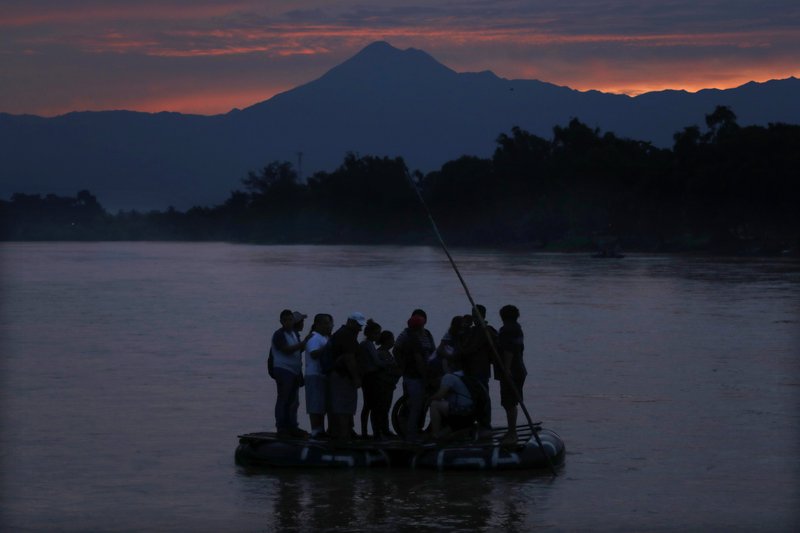 Central American migrants stand on a raft to cross the Suchiate River from Guatemala to Mexico, with the Tacana volcano in the background, near Ciudad Hidalgo, Mexicoin, early morning on 10 June 2019. A record 71 million people were forcibly displaced around the world in 2018, according to a report last month by the United Nations refugee agency, in places as diverse as Turkey, Uganda, Bangladesh, and Peru. Photo: Marco Ugarte / AP Photo