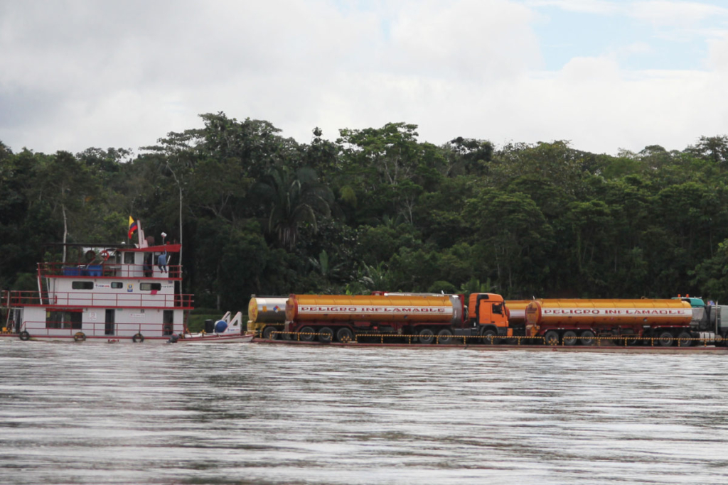 Oil trucks are hauled on boats between extraction sites in Ecuador’s Yasuni National Park. This is regular traffic along the Napo river, as there are no roads in these areas. In 2019, the Ecuadoran government approved two new controversial plans to drill for oil farther into Yasuni National Park, which will also encroach on the Intangible Zone (known by its Spanish acronym ZITT), a special area within the park created to protect the two uncontacted indigenous nations that live there, the Tagaeri and Taromenane. Photo: Kimberley Brown / Mongabay