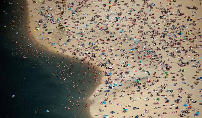 Aerial view of people cooling off at a lake in Haltern am See, western Germany, on 26 June 2019. Temperatures in Gemany reached as high as 38.6°C that day, setting a new all-time German heat record for June that had stood since 1947. That record was beaten again on Sunday, 30 June 2019, with a 39.6°C reading at river Saale. Photo: Ina Fassbender / AFP / Getty Images