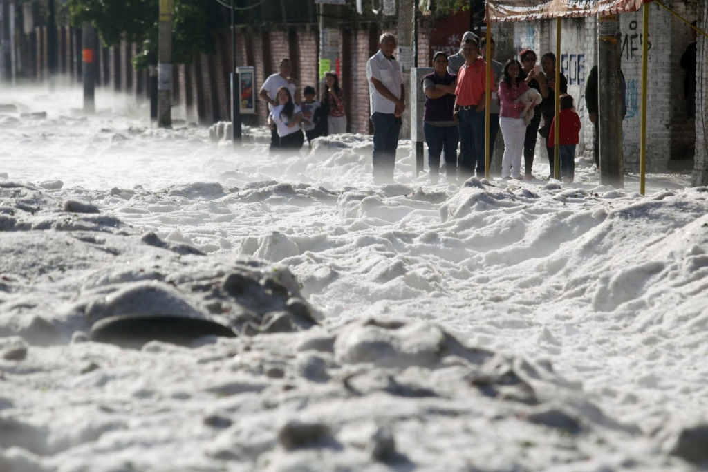 People remain on the sidewalk of a street covered with hail in the eastern area of the Mexican city of Guadalajara, on 30 June 2019. Photo: Ulises Ruiz / AFP / Getty Images