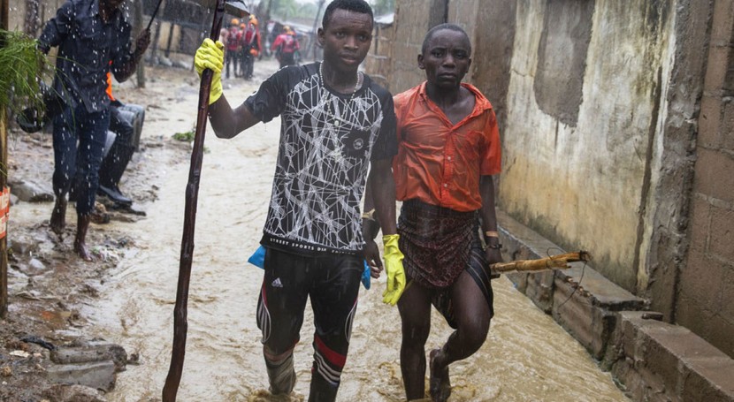 Two young men walk in the flooded Shibaburi area of Pemba after heavy rains poured down in the Pemba region of Mozambique, April 2019. Photo: Wikus De Wet / UNICEF