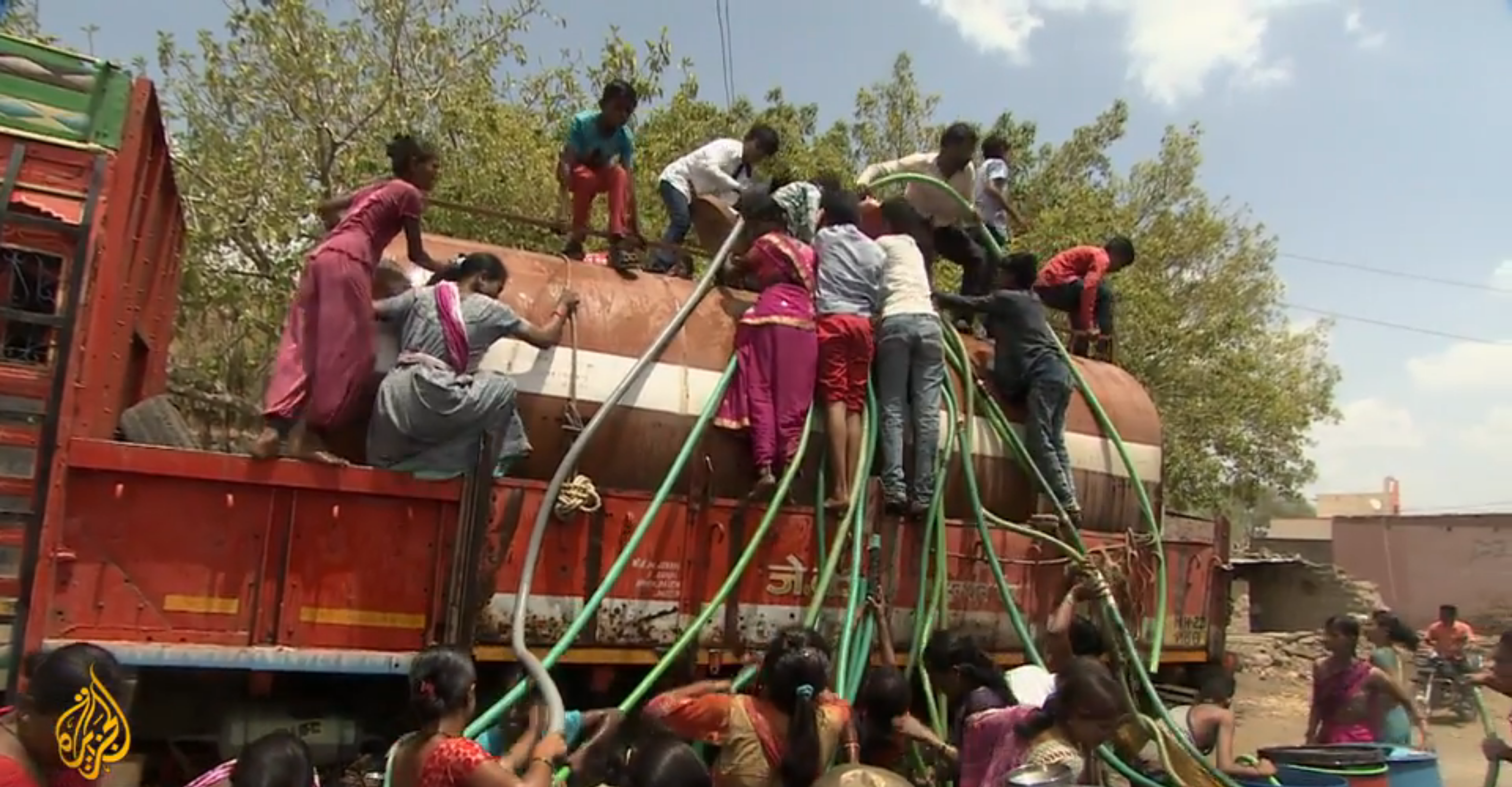 Villagers in Maharashtra state climb on a water truck to attach hoses for their daily water supply during India’s crippling drought of 2019. Photo: Al Jazeera