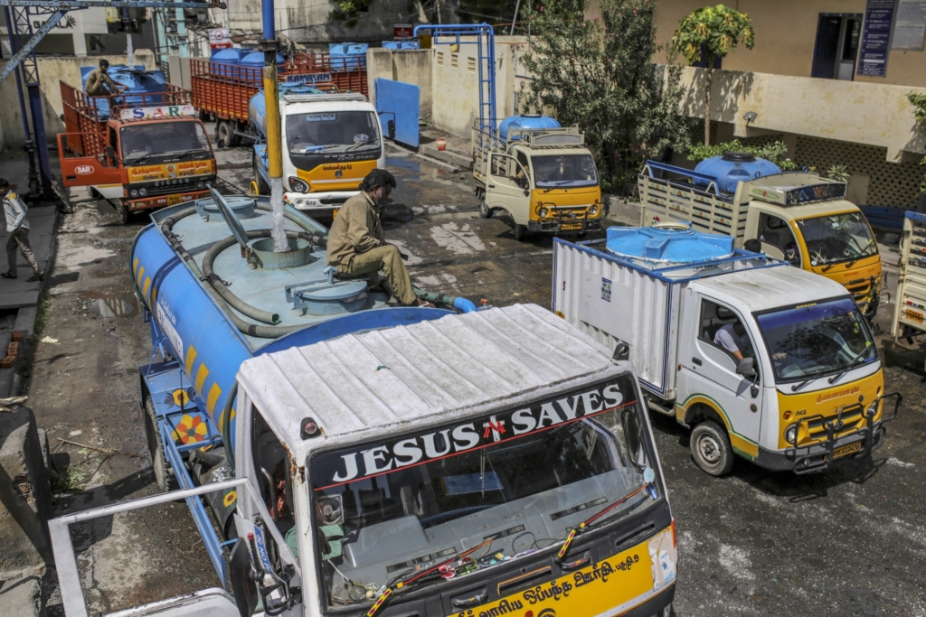 Water tankers queue at a government-run water filling station in Chennai. One truck has a sign in the windshield that reads, “Jesus Saves”. Photo: Dhiraj Singh / Bloomberg