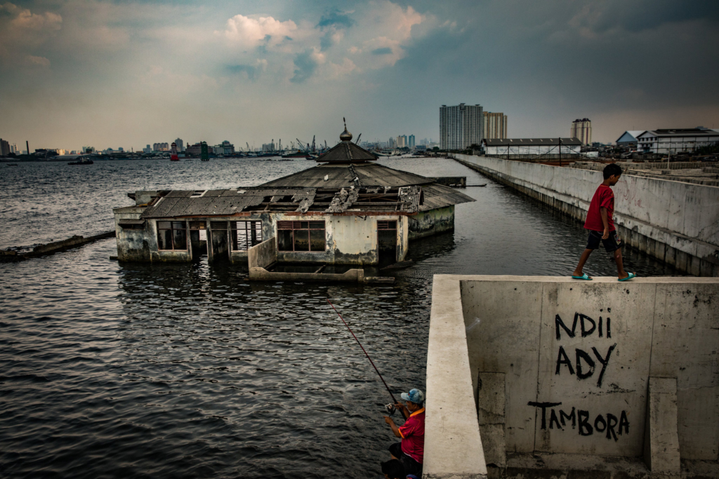 An abandoned house in Jakarta, Indonesia stands in the waters of the Java Sea, located on the ocean side of a sea wall, 21 December 2017. Subsidence is causing Jakarta to sink 10-20cm per year, one of the fastest rates in the world. Photo: Josh Haner / The New York Times