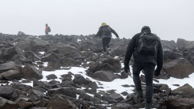 Dominic Boyer, Cymene Howe, and their student Magnus Sigurdsson climb into the mountains in August 2019 to drill holes for the Okjokull glacier memorial plaque. Photo: Josh Okun / BBC News