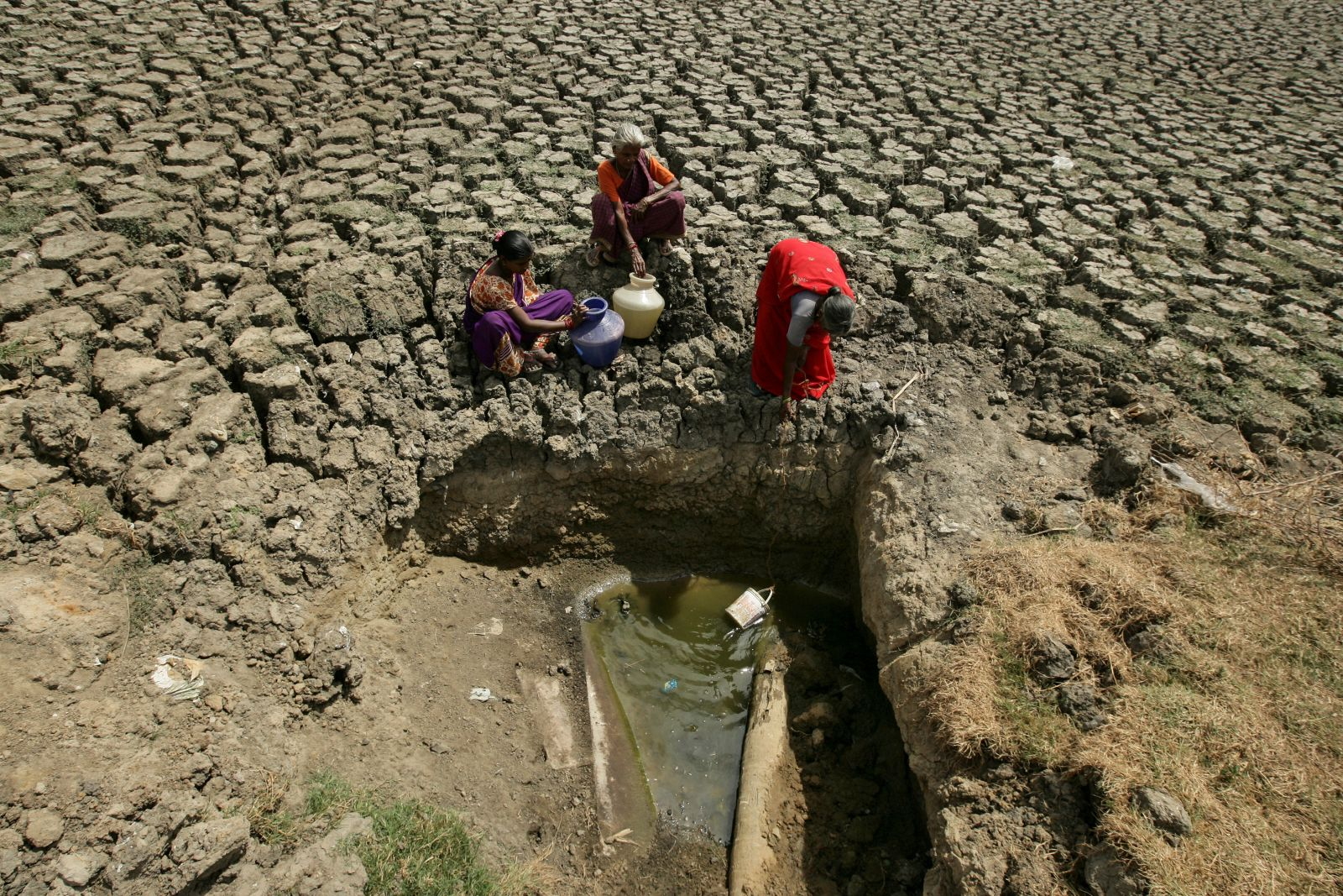 Women fetch water from an opening made at a dried-up lake in Chennai, India, on 11 June 2019. Photo: P. Ravikumar / Reuters