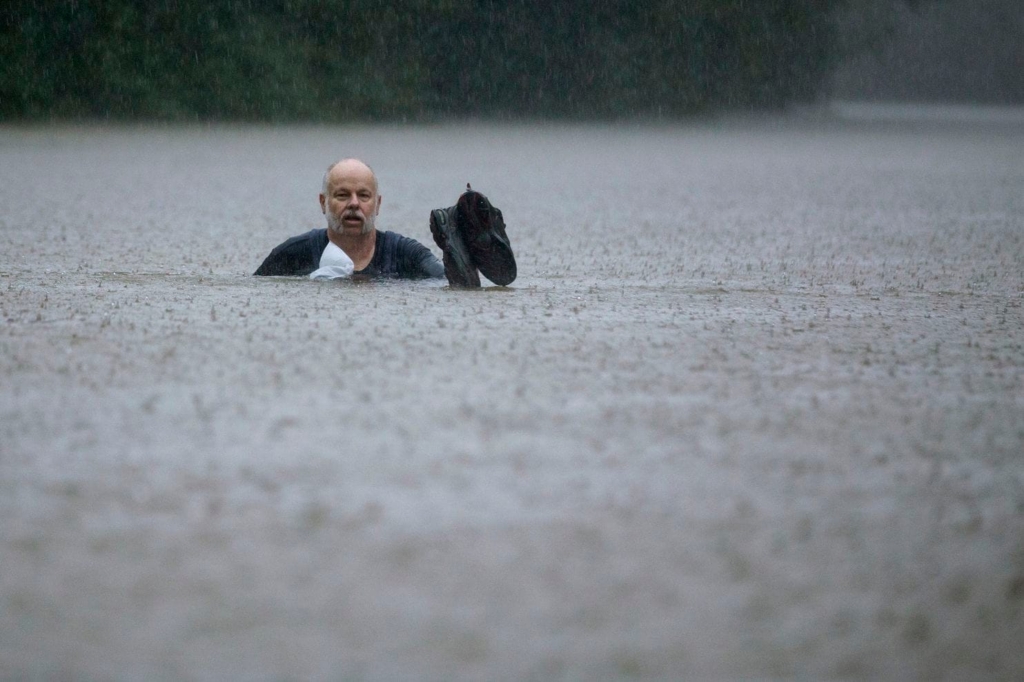A man wades out through neck-deep floodwaters caused by heavy rain from Tropical Depression Imelda on Thursday, 19 September 2019, in Patton Village, Texas. Photo: Brett Coomer / Houston Chronicle / AP
