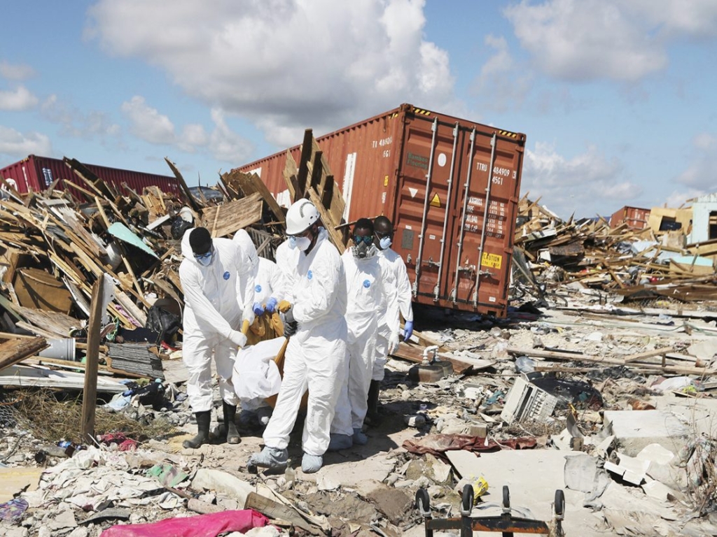 A recovery crew carries a body from The Mudd, a neighborhood in Abaco, Bahamas, that was demolished by Hurricane Dorian, 21 September 2019. Photo: Rachel Knowles / The Nassau Guardian