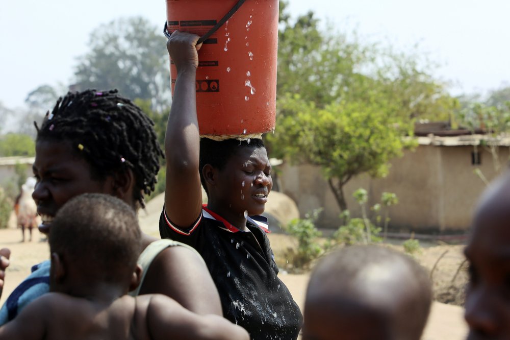 A woman goes home after fetching water at a borehole in Harare, Zimbabwe, on 24 September 2019.The more than 2 million residents of Zimbabwe’s capital and surrounding towns are now without water after authorities shut down the city’s main treatment plant, raising new fears about disease after a recent cholera outbreak while the economy crumbles further. Photo: Tsvangirayi Mukwazhi / AP Photo