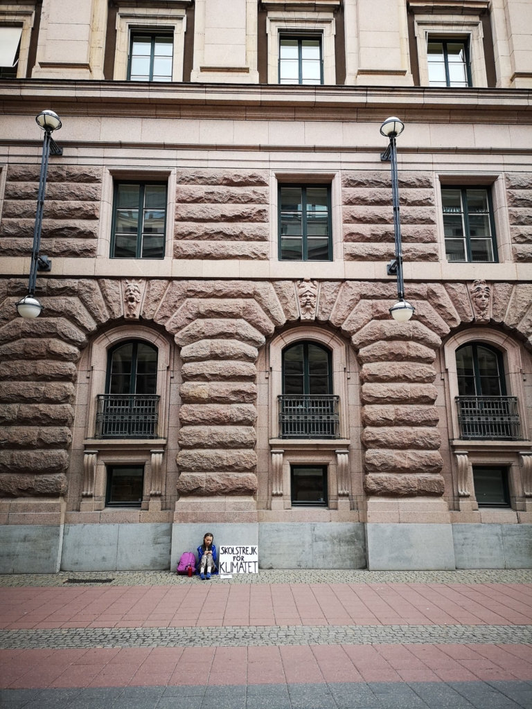 Greta Thunberg outside of the Swedish parliament (Sveriges Riksdag), 20 August 2018. She was supposed to start school again after a long summer break, but instead of rejoining her classmates, the 15-year-old seated herself against the stone facade of the Swedish Parliament’s main building in central Stockholm, with a sign that read, “School Strike for the Climate”. Photo: Adam Johansson