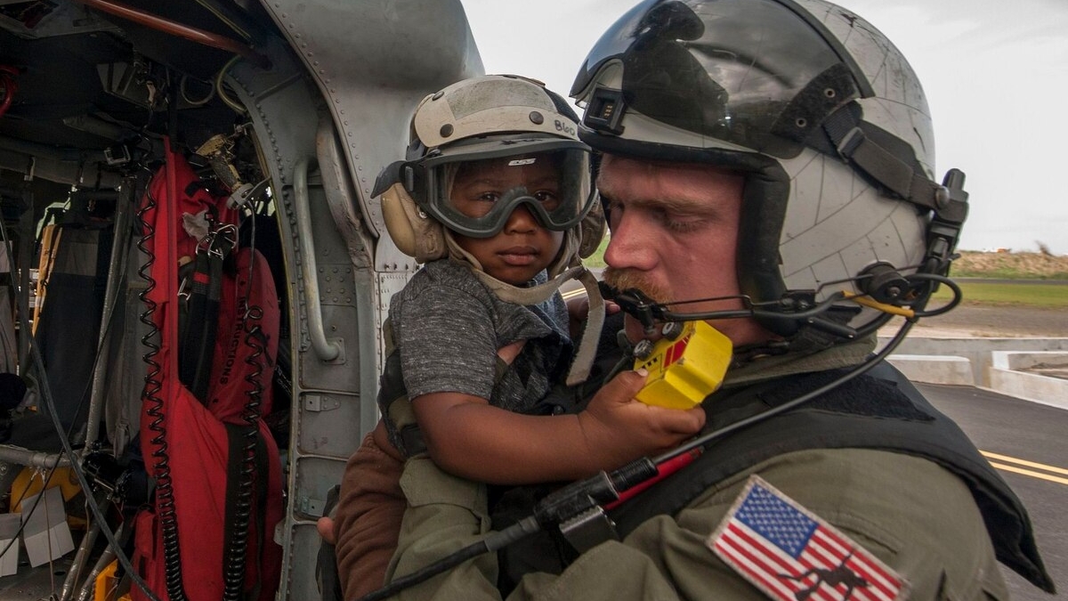 Naval Aircrewman (Helicopter) 2nd Class Brandon Larnard, from Helicopter Sea Combat Squadron 22, carries an evacuee in the wake of Hurricane Maria on the island of Dominica in 2017. The Navy recently did away with a task force dedicated to the effects of climate change, reversing an initiative by the Obama administration. Photo: Mass Communication Specialist 3rd Class Sean Galbreath / U.S. Navy