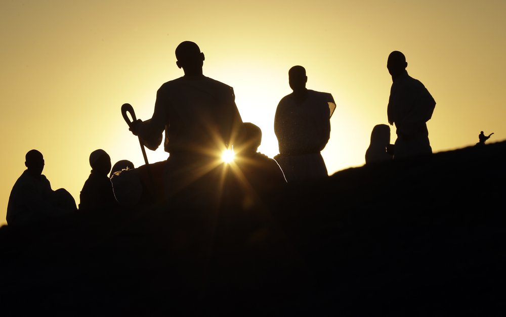 Zimbabweans sit and pray on top of a large rock on the outskirts of Harare, Zimbabwe, 8 September 2019. Photo: Themba Hadebe / AP Photo