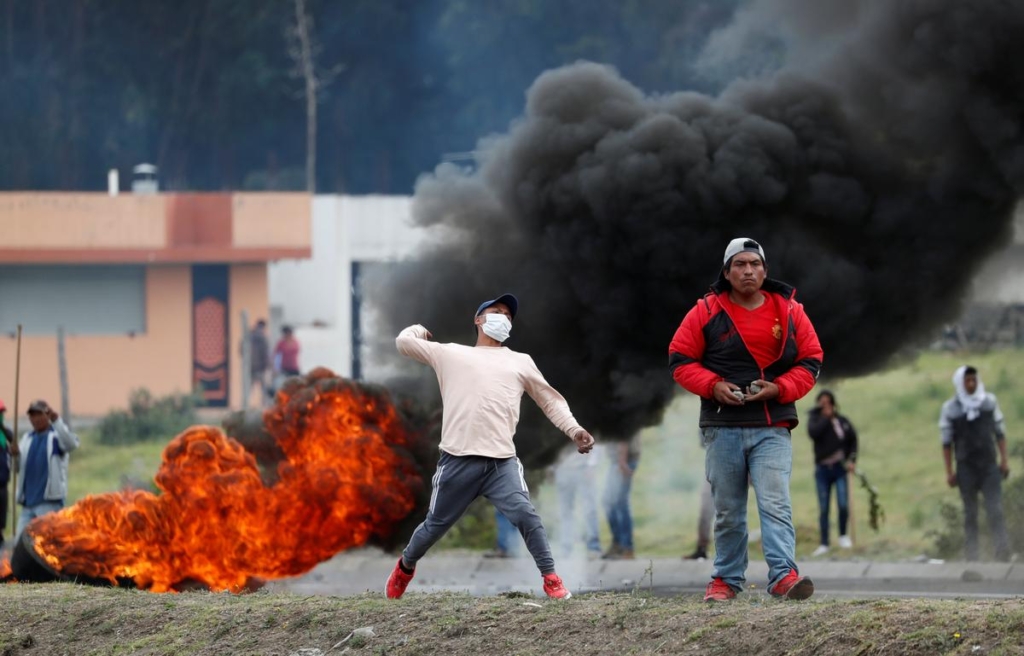 A demonstrator aims to throw as people block a road in Lasso, Ecuador, amid clashes with soldiers during protests after Ecuador’s President Lenin Moreno’s government ended four-decade-old fuel subsidies, 6 October 2019. Photo: Carlos Garcia Rawlins / REUTERS