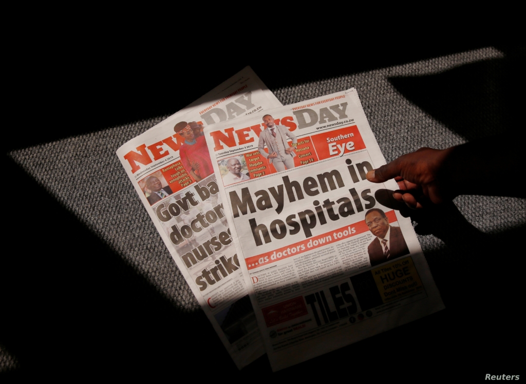 A man picks up a private daily newspaper with a headline that reads, “Mayhem in hospitals”, on the striking government doctors in Harare, Zimbabwe, 4 September 2019. Photo: Philimon Bulawayo / REUTERS