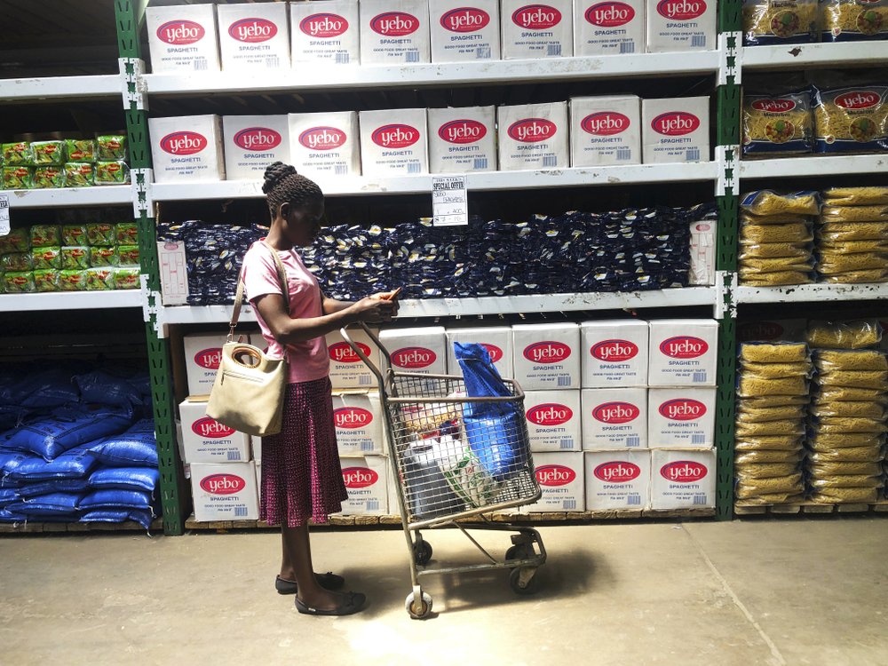 A woman does a quick calculation on her phone before buying groceries at a shop in Harare, on 9 October 2019. Hyperinflation is changing prices so quickly in the southern African nation that what you would see displayed on a supermarket shelf might change by the time you reach the checkout. Photo: Tsvangirayi Mukwazhi / AP Photo