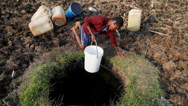 A woman fetches water from a well in Warren Park suburb, Harare, Zimbabwe, on 24 September 2019. Photo: Philimon Bulawayo / Reuters