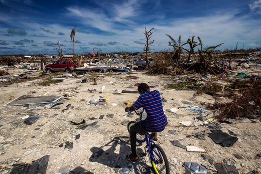Anthony Petit Frere, 12, rides through the Mudd community of Marsh Harbour, on Great Abaco in the Bahamas on 24 September 2019. The community was wiped out in Hurricane Dorian. Bahamian officials expect the number of fatalities from this area will rise. Anthony’s family lost everything in the storm and are living somewhere else. Photo: Andrew West / The USA Today Network-Florida