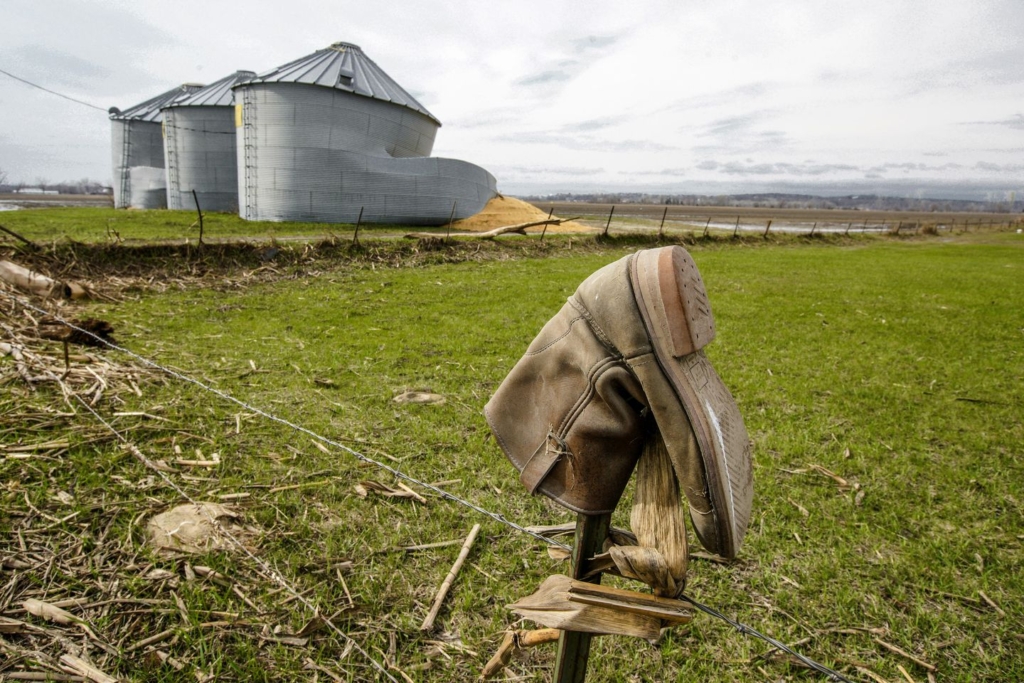 Destroyed grain silos, a result of flooding in Spring 2019, spill corn onto a muddy field, are seen on a farm in Bellevue, Nebraska. Photo: Nati Harnik / The Washington Post