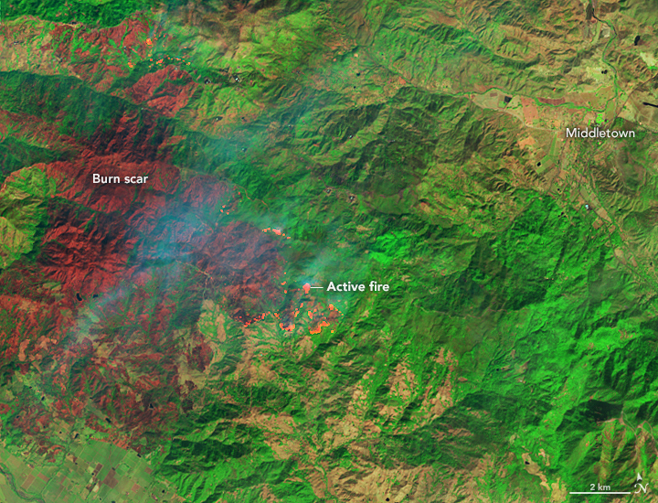 False-color satellite view of the burn scar from the Kincade Fire as it appeared on 26 October 2019. The image combines shortwave-infrared, near-infrared, and green light from Landsat 8 (OLI bands 7-5-4) to better distinguish between burned vegetation (brown) and unburned vegetation (green). The brightest reds are active fire fronts. Photo: Joshua Stevens / Lauren Dauphin / NASA Earth Observatory