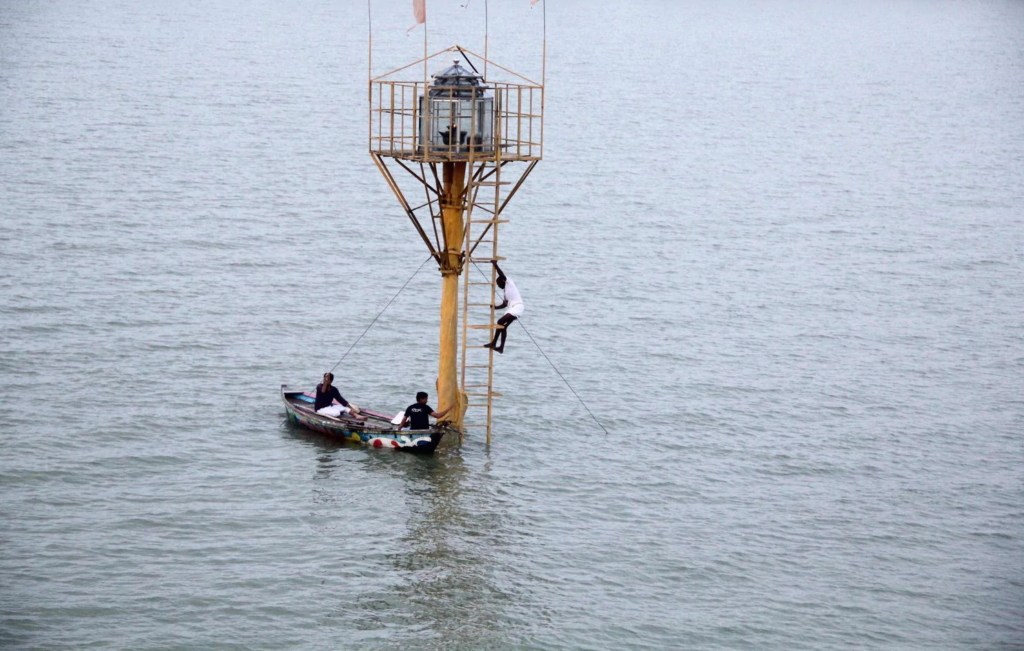 A Hindu priest climbs down a ladder after lighting an oil lamp in a temple built on a 35-feet high bamboo pole standing in floodwaters on the banks of the River Ganges near the Sangam area in Allahabad on 22 September 2019. Photo: Sanjay Kanojia / AFP / Getty Images