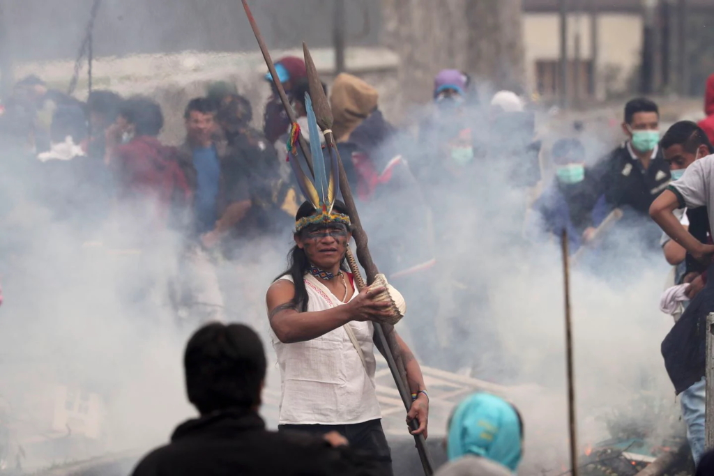 An indigenous protester stands in the middle of tear gas during clashes with police in Quito, Ecuador, Friday, 11 October 2019. Protests, which began when President Lenin Moreno’s decision to cut subsidies led to a sharp increase in fuel prices, have persisted for days. Photo: Dolores Ochoa / AP