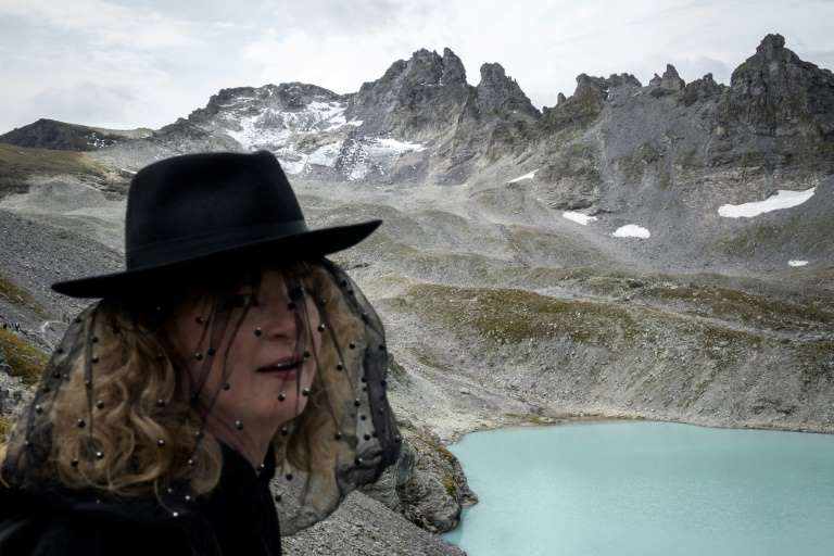 A mourner, dressed in black, stands in the Swiss Alps where the Pizol glacier once existed. The “funeral march” was held on 22 September 2019 to mark the disappearance of the Pizol glacier. Photo: Fabrice Coffrini