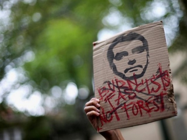 An activist holds a sign with an illustration of Brazilian President Jair Bolsonaro that reads, “Burn fascists, not forests”, as they demand more Amazon rainforest protection at the embassy of Brazil in Mexico City, Mexico 23 August 2019. Photo: Reuters