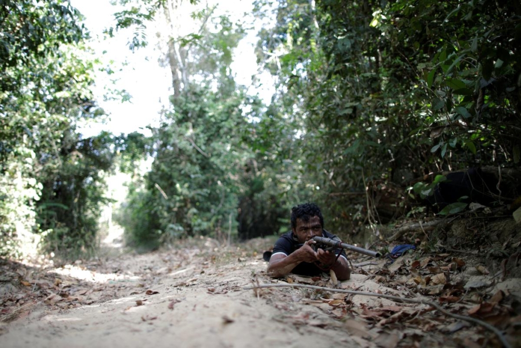 Indigenous leader Paulo Paulino Guajajara holds a gun during the search for illegal loggers on Arariboia indigenous land near the city of Amarante, Maranhao state, Brazil, 11 September 2019. He was hunting on 1 November 2019 inside the Arariboia reservation in Maranhao state when he was attacked and killed by illegal loggers. Photo: Ueslei Marcelino / REUTERS