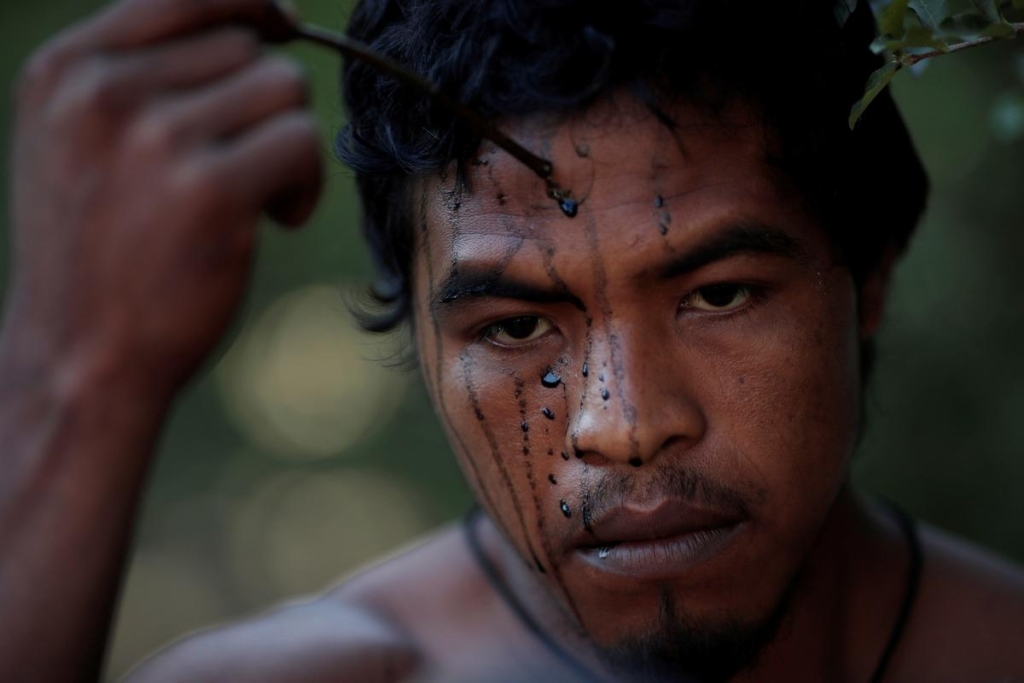 Indigenous leader Paulo Paulino Guajajara paints his face for a photo shoot in September 2019. He was hunting on 1 November 2019 inside the Arariboia reservation in Maranhao state when he was attacked and killed by illegal loggers. Photo: Ueslei Marcelino / REUTERS