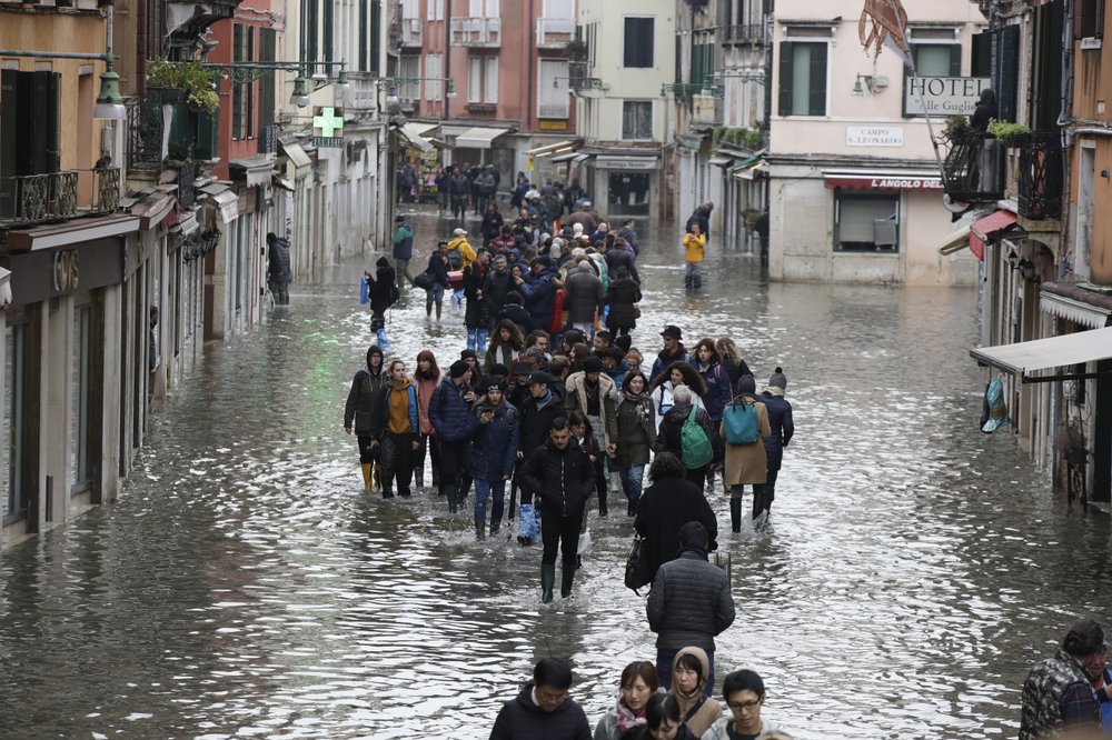 People wade through floodwater in Venice, 13 November 2019. Photo: Luca Bruno / AP Photo