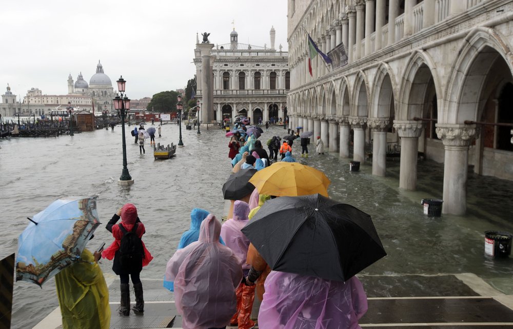 People walk on catwalk set up on the occasion of a high tide, in a flooded Venice, Italy, 12 November 2019. Photo: Luca Bruno / AP Photo