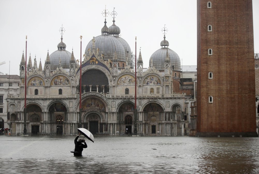 A photographer takes pictures of St Mark’s Basilica in a flooded St. Mark’s Square, in Venice, Italy, 12 November 2019. Photo: Luca Bruno / AP Photo