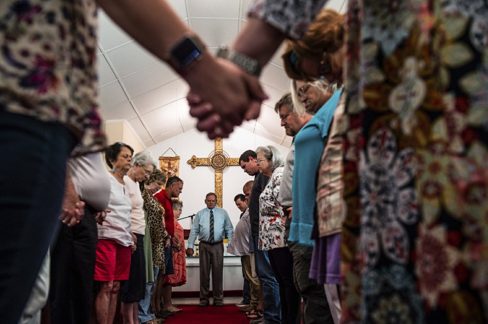 Members of the congregation at Elkmont United Methodist Church hold hands at the conclusion of a prayer vigil, Tuesday, 3 September 2019, in Elkmont, Alabama. A 14-year-old boy admitted to killing five members of his family in Elkmont, including his three younger siblings, Alabama authorities said Tuesday. Photo: Dan Busey / The Decatur Daily / AP