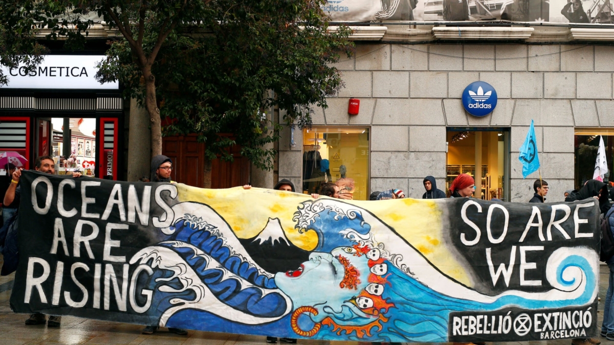 Extinction Rebellion protesters in Madrid during the COP25 climate summit in December 2019 hold a banner that reads, “Oceans are rising. So are we.” Photo: Javier Barbancho / Reuters