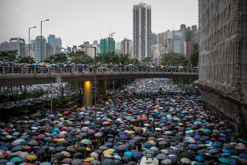 Thousands of anti-government protesters, carrying open umbrellas, march on a street after leaving a rally in Victoria Park on 18 August 2019 in Hong Kong, China. Photo: Getty Images