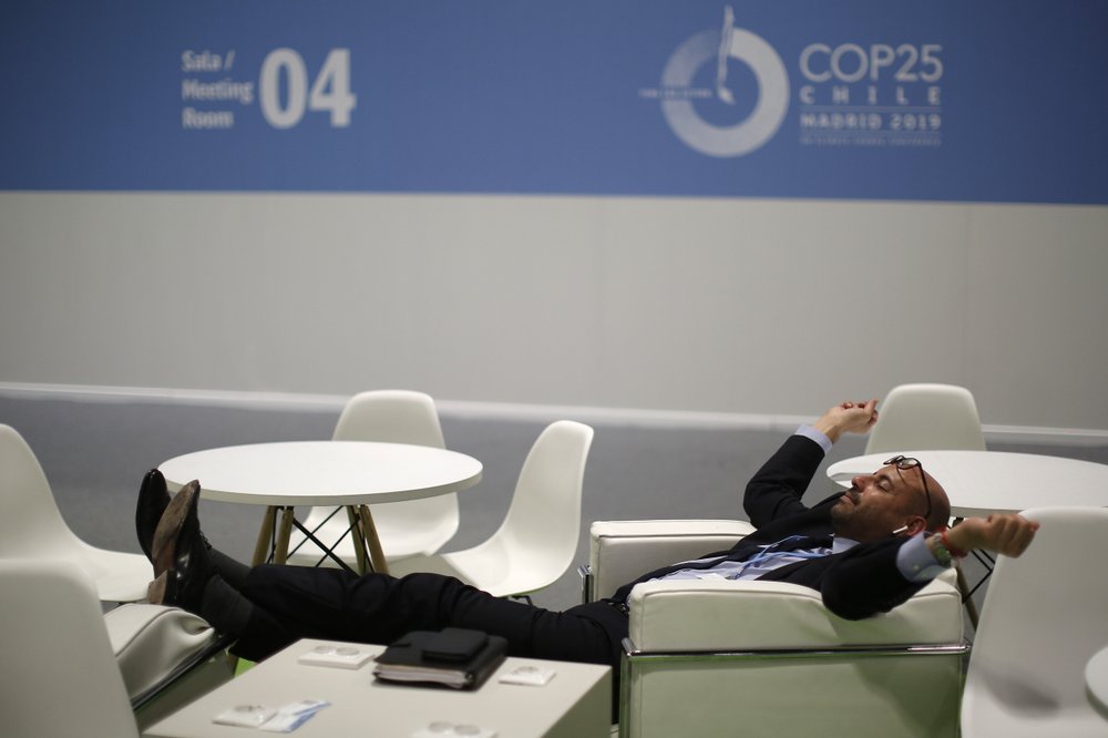 A visitor rests at the COP25 climate talks congress in Madrid, Spain, Saturday, 14 December 2019. The United Nations Secretary-General warned that failure to tackle global warming could result in economic disaster. Photo: Manu Fernandez / AP Photo