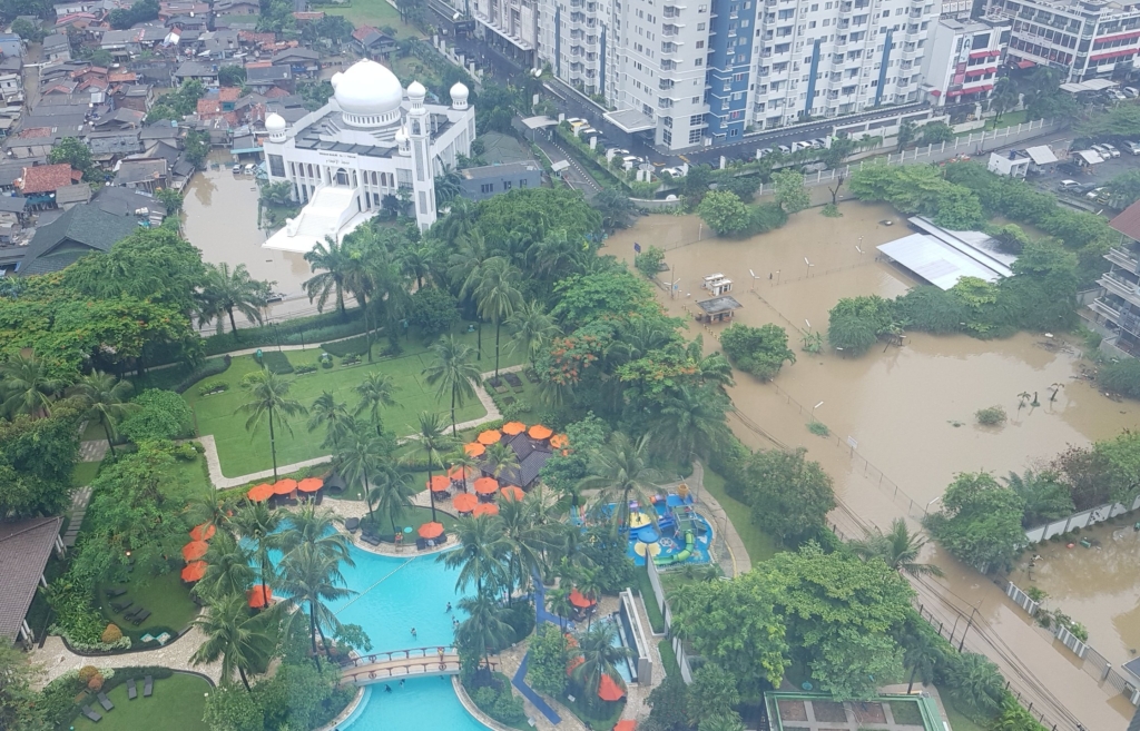 Aerial view of the pristine swimming pool at Jakarta’s Shangri-la Hotel, virtually untouched by flooding as the adjacent kampong — or village — was submerged in muddy floodwaters on 31 December 2019. Photo: Sakinah Ummu Haniy / Twitter