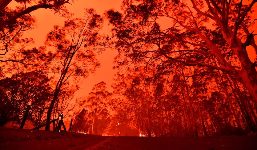 The afternoon sky glows red from bushfires in the area around the town of Nowra in the Australian state of New South Wales on 31 December 2019. Photo: Saeed Khan / AFP / Getty Images