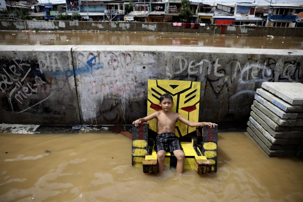 A young boy sits on a chair in a flooded neighborhood in Jakarta, Indonesia, Thursday, 2 January 2020. Severe flooding in the capital as residents celebrated the new year has killed scores of people and displaced tens of thousands, the country's disaster management agency said. Photo: Dita Alangkara / AP Photo