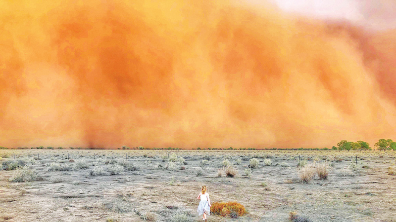 A child runs toward a dust storm in Mullengudgery in New South Wales, Australia, 19 January 2020. Dust storms hit many parts of Australia's western New South Wales as a prolonged drought continues. Photo: AFP